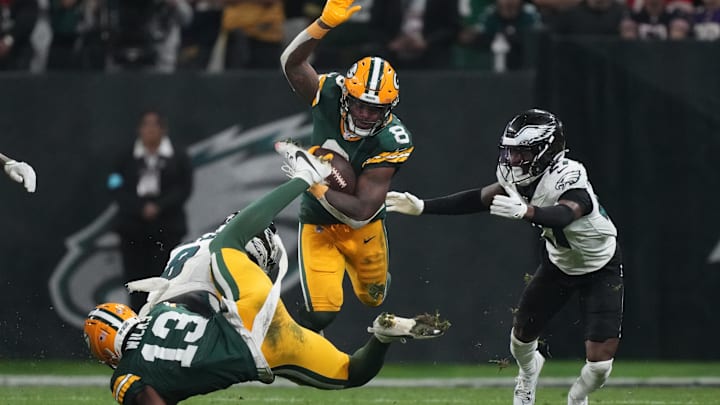 With a block by Dontayvion Wicks, Packers RB Josh Jacobs gets into the open field against the Eagles.