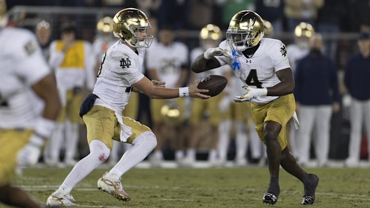 Nov 29, 2025; Stanford, California, USA;  Notre Dame Fighting Irish quarterback CJ Carr (13) hands the ball off to Notre Dame Fighting Irish running back Jeremiyah Love (4) during the first quarter against the Stanford Cardinal at Stanford Stadium. Mandatory Credit: Stan Szeto-Imagn Images