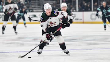 Apr 6, 2023; Seattle, Washington, USA; Arizona Coyotes defenseman Victor Soderstrom (77) advances the puck against the Seattle Kraken during the first period at Climate Pledge Arena. Mandatory Credit: Steven Bisig-Imagn Images