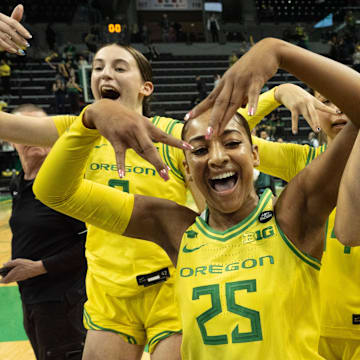 Oregon’s Elisa Mevius, left, Deja Kelly and Katie Fiso celebrate with teammates after defeating Washington at Matthew Knight Arena Wednesday, Feb. 12, 2025.