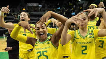 Oregon’s Elisa Mevius, left, Deja Kelly and Katie Fiso celebrate with teammates after defeating Washington at Matthew Knight Arena Wednesday, Feb. 12, 2025.