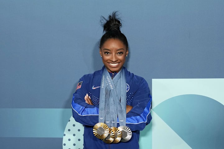 Simone Biles of the United States poses for a photo with her three gold and one silver medal after day three of the gymnastic
