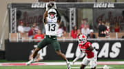 Oct 18, 2025; Bloomington, Indiana, USA; Michigan State Spartans wide receiver Chrishon McCray (13) catches a pass against Indiana Hoosiers defensive back D'Angelo Ponds (5) during the first half at Memorial Stadium. Mandatory Credit: Robert Goddin-Imagn Images