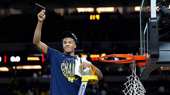 Michigan guard Trey McKenney (1) cuts a piece of the net as the teams celebrates beating Connecticut to win the NCAA national championship at Lucas Oil Stadium in Indianapolis on Monday, April 6, 2026.