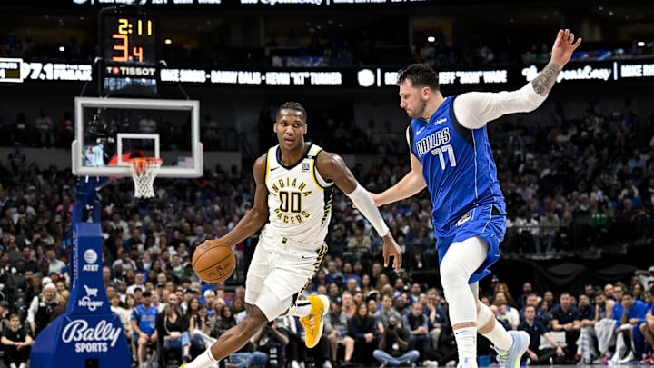 Mar 5, 2024; Dallas, Texas, USA; Indiana Pacers guard Bennedict Mathurin (00) brings the ball up court past Dallas Mavericks guard Luka Doncic (77) during the second half at the American Airlines Center. Mandatory Credit: Jerome Miron-Imagn Images