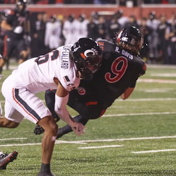 Nov 1, 2025; Salt Lake City, Utah, USA; Utah Utes wide receiver Ryan Davis (9) is tackled in the end zone for a touchdown by Cincinnati Bearcats defensive back Tre Gola-Callard (6) during the first quarter at Rice-Eccles Stadium. Mandatory Credit: Rob Gray-Imagn Images