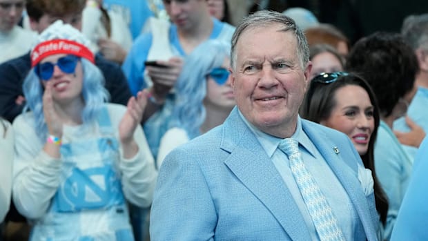 North Carolina Tar Heels football coach Bill Belichick smiles before a UNC basketball game.