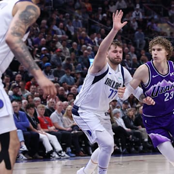 Mar 25, 2024; Salt Lake City, Utah, USA; Utah Jazz forward Lauri Markkanen (23) drives against Dallas Mavericks guard Luka Doncic (77) during the third quarter at Delta Center. Mandatory Credit: Rob Gray-Imagn Images