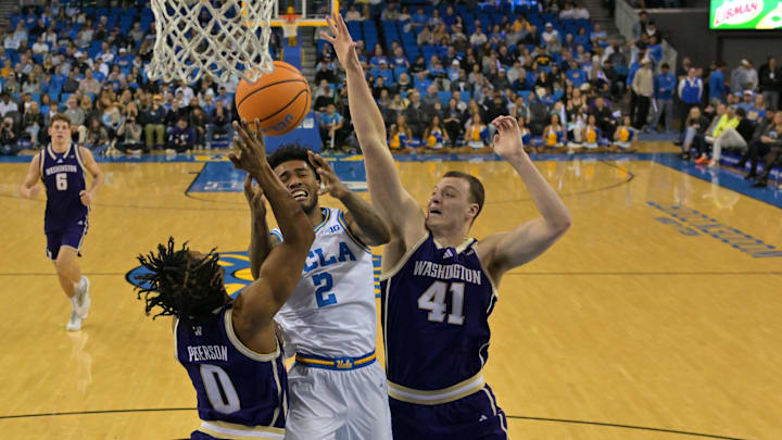 Feb 7, 2026; Los Angeles, California, USA;  UCLA Bruins guard Donovan Dent (2) is defended by Washington Huskies guard Quimari Peterson (0) and forward Jacob Ognacevic (41) as he drives to the basket in the first half at Pauley Pavilion presented by Wescom Financial. Mandatory Credit: Jayne Kamin-Oncea-Imagn Images