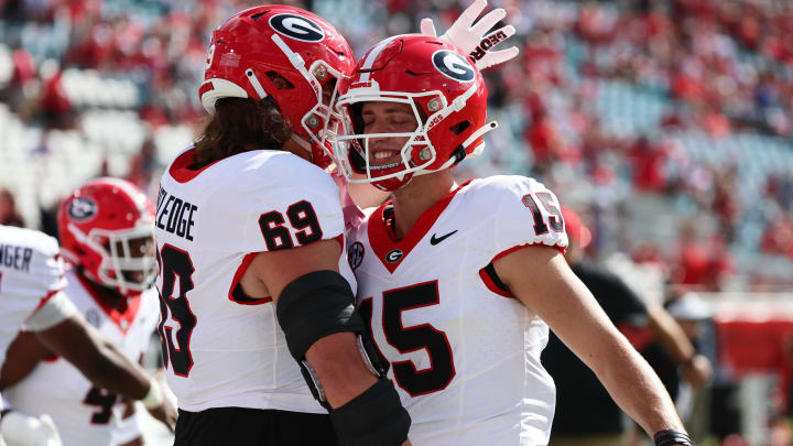 Oct 28, 2023; Jacksonville, Florida, USA; Georgia Bulldogs quarterback Carson Beck (15) and offensive lineman Tate Ratledge (69) hug prior to the game against the Florida Gators at EverBank Stadium. Mandatory Credit: Kim Klement Neitzel-USA TODAY Sports