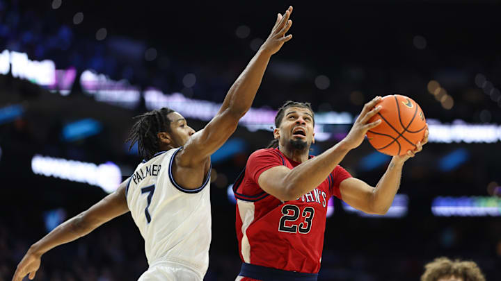 Jan 17, 2026; Philadelphia, Pennsylvania, USA; St. John's basketball forward Bryce Hopkins (23) drives for a shot past Villanova Wildcats guard Malachi Palmer (7) during the second half at Xfinity Mobile Arena.
