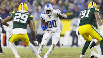 Jan 8, 2023; Green Bay, Wisconsin, USA;  Detroit Lions running back Jamaal Williams (30) rushes with the football during the fourth quarter against the Green Bay Packers at Lambeau Field. Mandatory Credit: Jeff Hanisch-Imagn Images