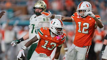 Sep 13, 2025; Miami Gardens, Florida, USA; Miami Hurricanes defensive back Bryce Fitzgerald (13) intercepts the football against the South Florida Bulls during the second quarter at Hard Rock Stadium. Mandatory Credit: Sam Navarro-Imagn Images