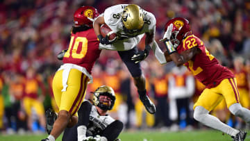 Nov 11, 2022; Los Angeles, California, USA; Colorado Buffaloes running back Alex Fontenot (8) is brought down by Southern California Trojans linebacker Ralen Goforth (10) and defensive back Ceyair Wright (22) during the first half at the Los Angeles Memorial Coliseum.