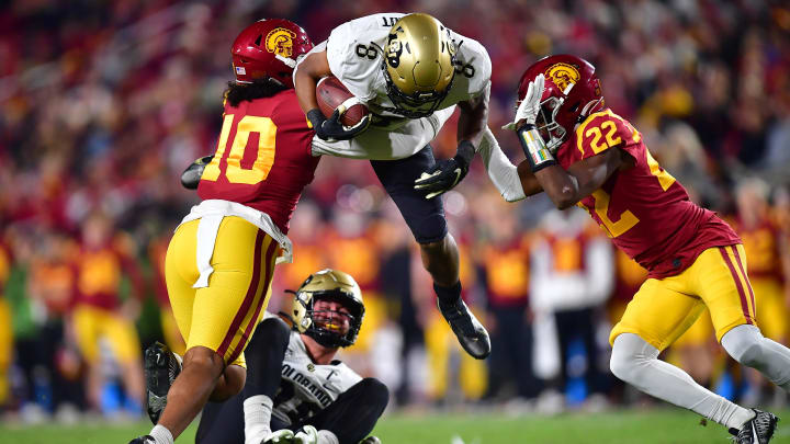Nov 11, 2022; Los Angeles, California, USA; Colorado Buffaloes running back Alex Fontenot (8) is brought down by Southern California Trojans linebacker Ralen Goforth (10) and defensive back Ceyair Wright (22) during the first half at the Los Angeles Memorial Coliseum.