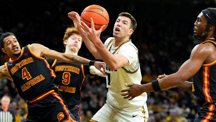 Iowa forward Alvaro Folgueiras (7) reaches for the ball against USC’s Chad Baker-Mazara (4), USC guard Ryan Cornish (9) and USC guard Kam Woods (13) Jan. 28, 2026 at Carver-Hawkeye Arena in Iowa City, Iowa.