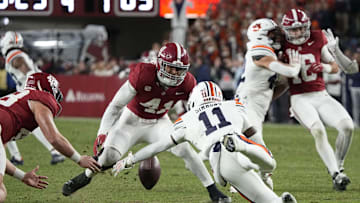 Nov 30, 2024; Tuscaloosa, Alabama, USA;  Auburn Tigers wide receiver Malcolm Simmons (11) fumbles a punt but recovers as Alabama Crimson Tide defensive back Prince Butler (48) and linebacker Justin Okoronkwo (41) close in during second half at Bryant-Denny Stadium. Alabama won 28-14. Mandatory Credit: Gary Cosby Jr.-Imagn Images