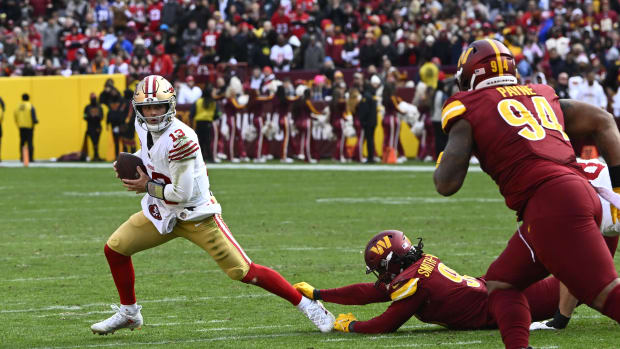 Brock Purdy (13) scrambles as Washington Commanders defensive tackle Daron Payne (94) defends