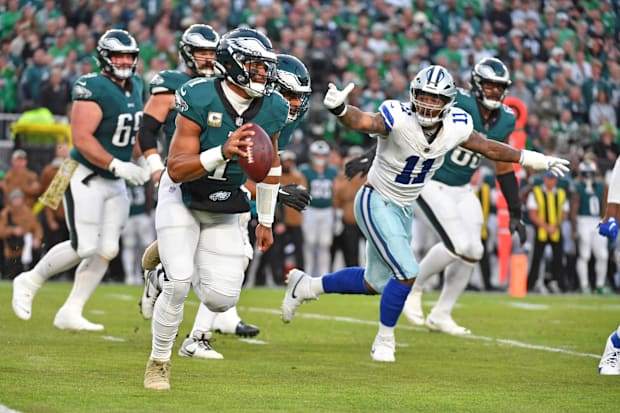 Philadelphia Eagles QB Jalen Hurts runs away from pressure by Dallas Cowboys linebacker Micah Parsons.