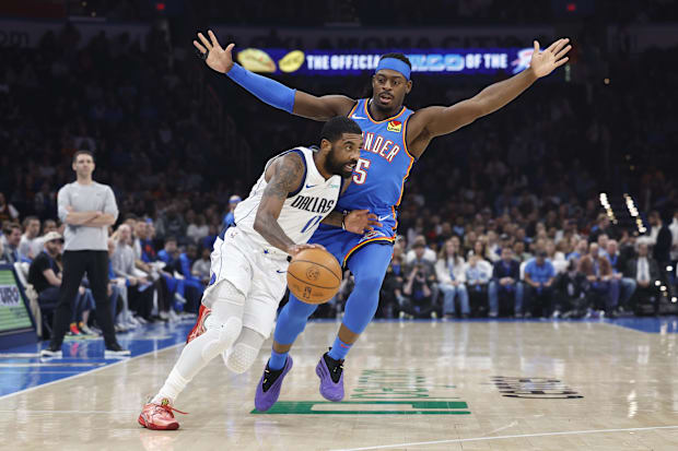 Dallas Mavericks guard Kyrie Irving (11) drives around Oklahoma City Thunder guard Luguentz Dort.