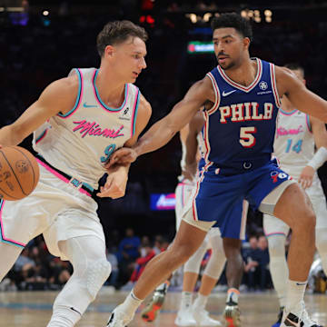 Apr 7, 2025; Miami, Florida, USA; Miami Heat guard Pelle Larsson (9) drives to the basketball as Philadelphia 76ers guard Quentin Grimes (5) defends during the second quarter at Kaseya Center. Mandatory Credit: Sam Navarro-Imagn Images