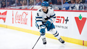 Oct 18, 2024; Winnipeg, Manitoba, CAN;  San Jose Sharks defenseman Matt Benning (5) looks to make a pass against the Winnipeg Jets during the second period at Canada Life Centre. Mandatory Credit: Terrence Lee-Imagn Images