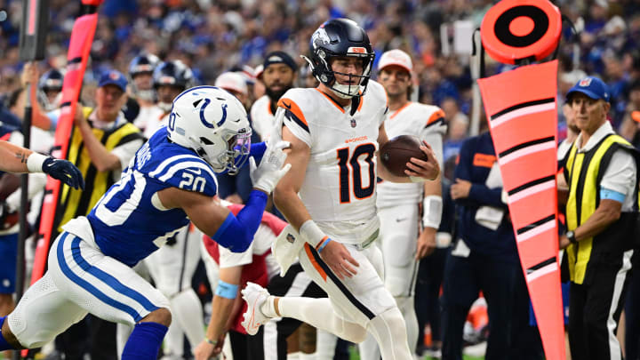 Aug 11, 2024; Indianapolis, Indiana, USA;  Denver Broncos quarterback Bo Nix (10) is pushed out of bounds by Indianapolis Colts safety Nick Cross (20) during the second quarter at Lucas Oil Stadium. 