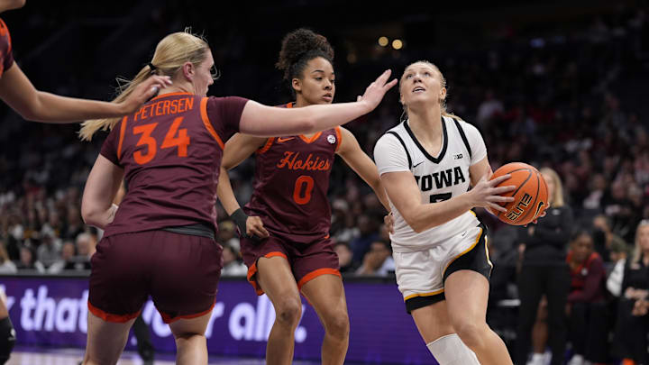 Nov 10, 2024; Charlotte, NC, USA; Iowa Hawkeyes guard Sydney Affolter (3) drives to the basket against Virginia Tech Hokies guard Lani White (0) and guard Kayl Petersen (34) during the first half at Spectrum Center. Mandatory Credit: Jim Dedmon-Imagn Images