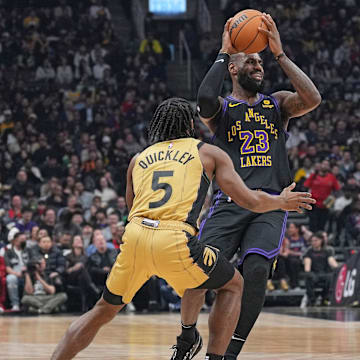 Apr 2, 2024; Toronto, Ontario, CAN; Los Angeles Lakers forward LeBron James (23) controls the ball as Toronto Raptors guard Immanuel Quickley (5) tries to defend during the first quarter at Scotiabank Arena. Mandatory Credit: Nick Turchiaro-Imagn Images