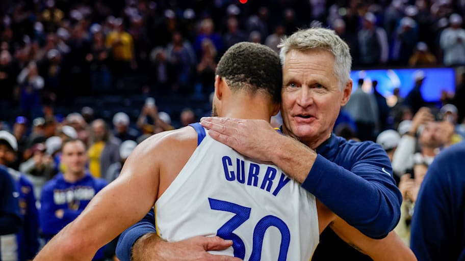 Golden State Warriors guard Stephen Curry embraces head coach Steve Kerr.