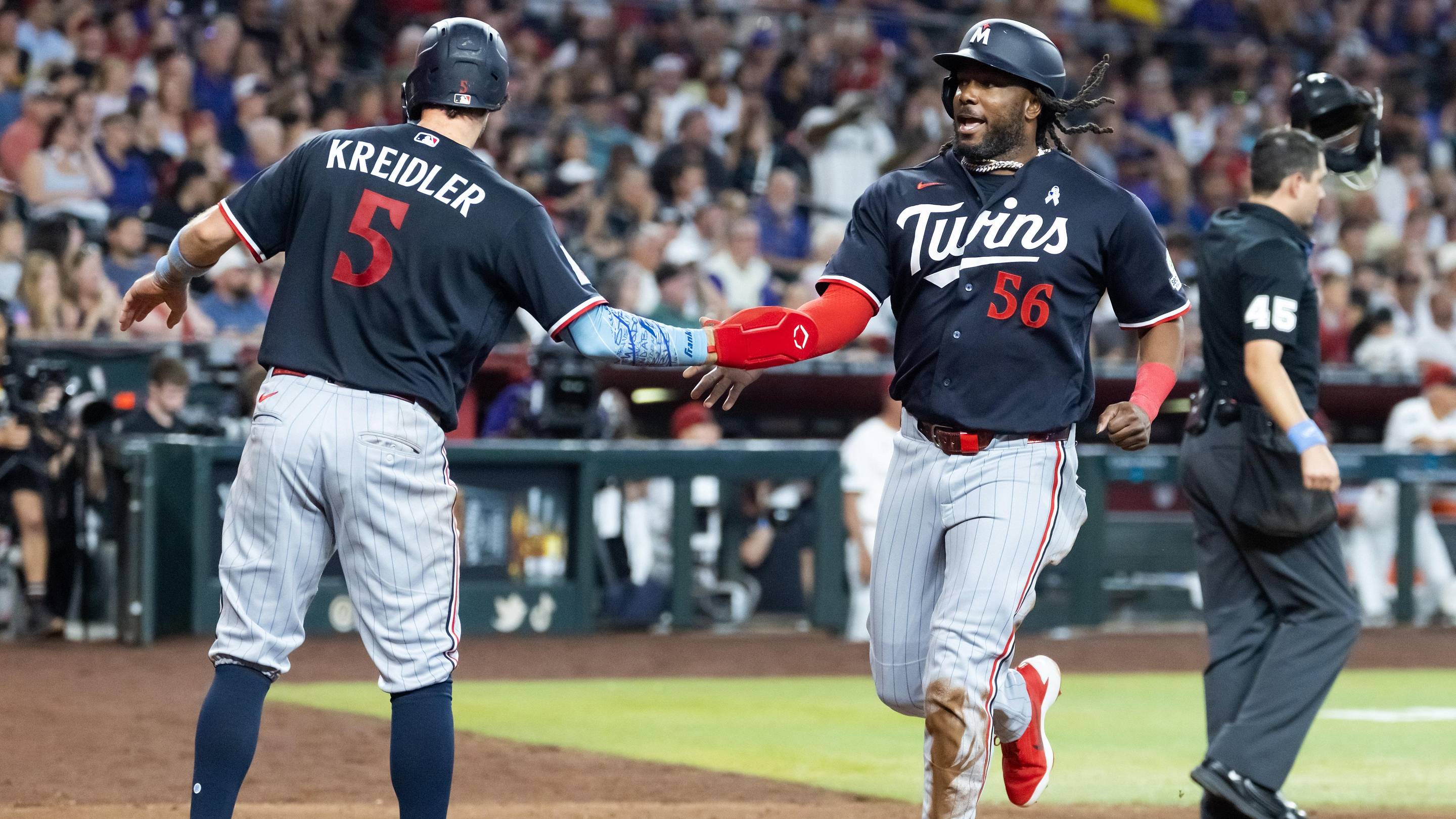 Jun 21, 2026; Phoenix, Arizona, USA; Minnesota Twins outfielder Josh Bell celebrates with Ryan Kreidler after scoring in the seventh inning against the Arizona Diamondbacks at Chase Field.
