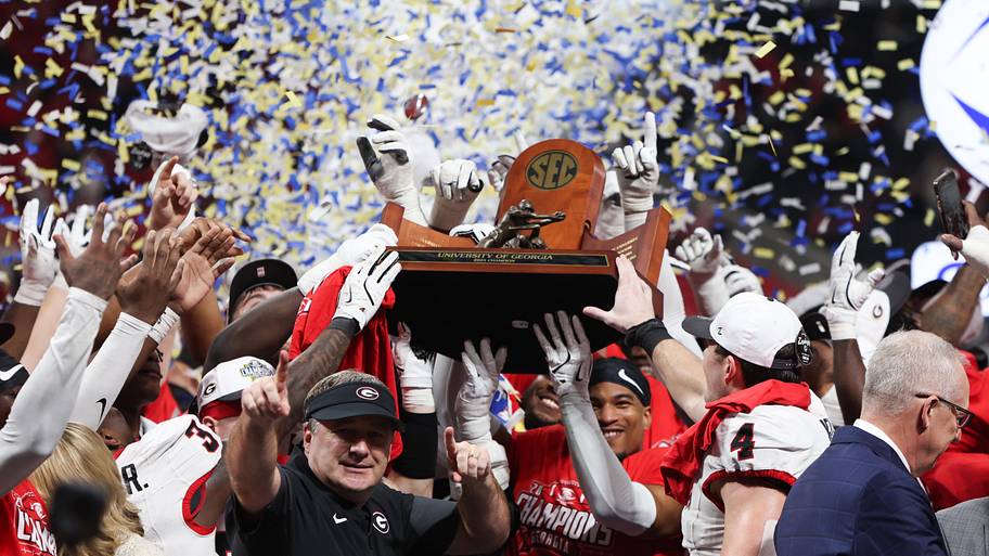 The Georgia Bulldogs lift the championship trophy after beating Alabama in the 2025 SEC championship game.
