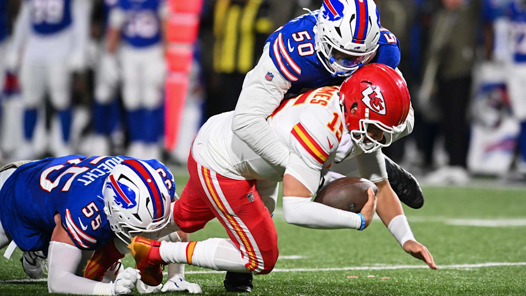 Nov 2, 2025; Orchard Park, New York, USA; Kansas City Chiefs quarterback Patrick Mahomes (15) is brought down by Buffalo Bills defensive end Michael Hoecht (55) and defensive end Greg Rousseau (50) in the third quarter at Highmark Stadium.