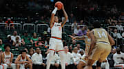 Dec 21, 2024; Coral Gables, Florida, USA; Miami Hurricanes guard Jalil Bethea (3) shoots the basketball over Mount St. Mary's Mountaineers guard Javon Ervin (23) during the second half at Watsco Center. Mandatory Credit: Sam Navarro-Imagn Images