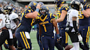 West Virginia University running back Jahiem White celebrates his three-yard touchdown run in the first quarter. 