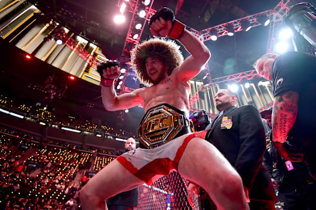Merab Dvalishvili (red gloves) celebrates after winning a UFC bantamweight title fight against Umar Nurmagomedov.