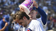 Jul 21, 2024; Chicago, Illinois, USA;  Chicago Cubs second base Nico Hoerner (2) is is doused by outfielder Pete Crow-Armstrong (52) after a bases loaded walk to beat the Arizona Diamondbacks in extra innings at Wrigley Field. 