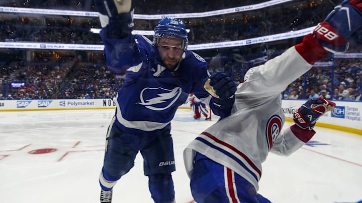Apr 19, 2026; Tampa, Florida, USA; Montreal Canadiens defenseman Kaiden Guhle (21) shoves Tampa Bay Lightning forward Zemgas Girgensons (28) into the boards during the third period in game one of the first round of the 2026 Stanley Cup Playoffs at Benchmark International Arena. Mandatory Credit: Morgan Tencza-Imagn Images