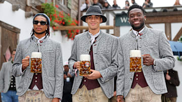 Michael Olise, Jamal Musiala und Alphonso Davies beim Teamauftritt des FC Bayern München auf dem Oktoberfest.