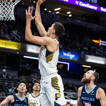 Oct 14, 2024; Indianapolis, Indiana, USA; Indiana Pacers forward Cole Swider (21) shoots the ball while Memphis Grizzlies center Jay Huff (30) defends in the second half at Gainbridge Fieldhouse. Mandatory Credit: Trevor Ruszkowski-Imagn Images