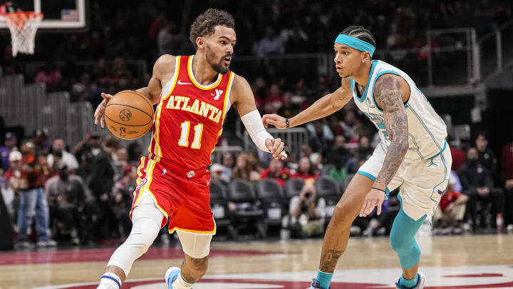 Apr 10, 2024; Atlanta, Georgia, USA; Atlanta Hawks guard Trae Young (11) dribbles past Charlotte Hornets guard Tre Mann (23) during the first half at State Farm Arena. Mandatory Credit: Dale Zanine-USA TODAY Sports