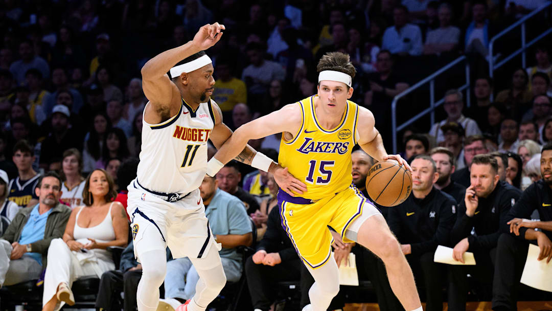 Mar 14, 2026; Los Angeles, California, USA; Los Angeles Lakers guard Austin Reaves (15) drives the ball while under pressure from Denver Nuggets guard Bruce Brown (11) during the first half at Crypto.com Arena. Mandatory Credit: William Liang-Imagn Images