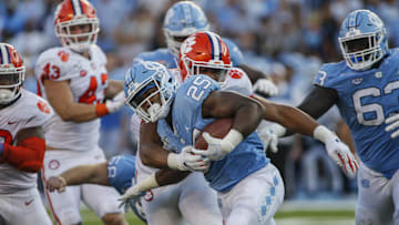 Sep 28, 2019; Chapel Hill, NC, USA; North Carolina Tar Heels running back Javonte Williams (25) fights for yards against the Clemson Tigers in the second half at Kenan Memorial Stadium. The Clemson Tigers won 21-20. Mandatory Credit: Nell Redmond-Imagn Images