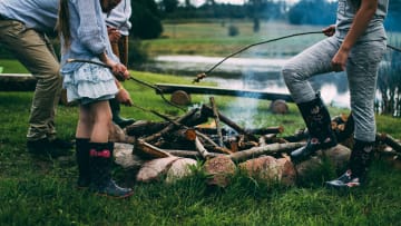 A family roasting food over a campfire