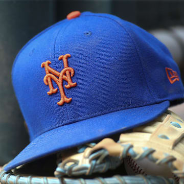 Jul 13, 2022; Atlanta, Georgia, USA; A detailed view of a New York Mets hat and glove in the dugout against the Atlanta Braves in the eighth inning at Truist Park. Mandatory Credit: Brett Davis-Imagn Images