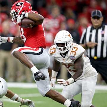 Jan 1, 2019; New Orleans, LA, USA; Georgia Bulldogs running back Elijah Holyfield (13) hurdles Texas Longhorns defensive back Brandon Jones (19) in the second half of the 2019 Sugar Bowl at the Mercedes-Benz Superdome. Mandatory Credit: Chuck Cook-Imagn Images