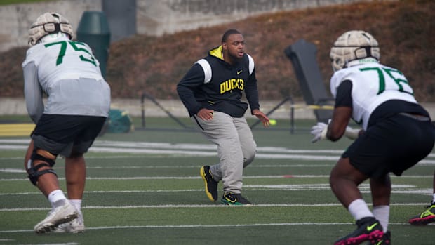 New Offensive Line coach A'lique Terry, center, runs a drill during the first practice of spring for Oregon Football Thursday