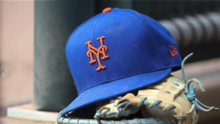 Jul 13, 2022; Atlanta, Georgia, USA; A detailed view of a New York Mets hat and glove in the dugout against the Atlanta Braves in the eighth inning at Truist Park. Mandatory Credit: Brett Davis-USA TODAY Sports