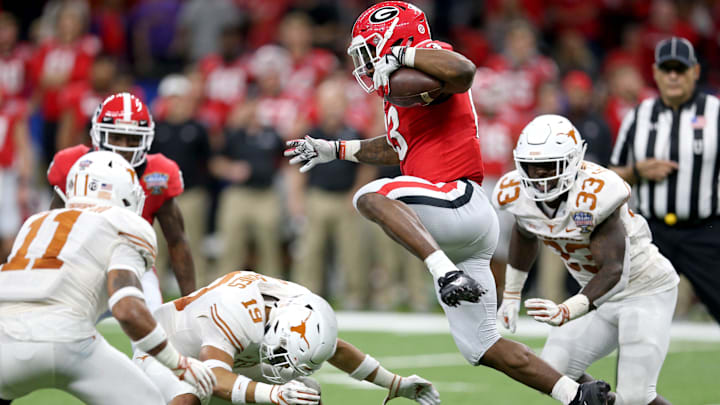 Jan 1, 2019; New Orleans, LA, USA; Georgia Bulldogs running back Elijah Holyfield (13) hurdles Texas Longhorns defensive back Brandon Jones (19) in the second half of the 2019 Sugar Bowl at the Mercedes-Benz Superdome. Mandatory Credit: Chuck Cook-Imagn Images