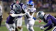 Oct 26, 2024; Manhattan, Kansas, USA; Kansas Jayhawks running back Devin Neal (4) is tackled by Kansas State Wildcats safety Jordan Riley (6) and safety VJ Payne (19) during the third quarter at Bill Snyder Family Football Stadium. Mandatory Credit: Scott Sewell-Imagn Images